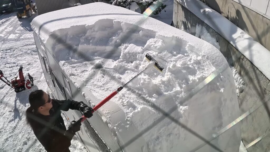スノーブラシで雪を落とします