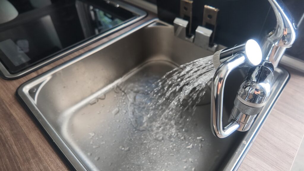 キッチンシンク蛇口から水が出ている画像