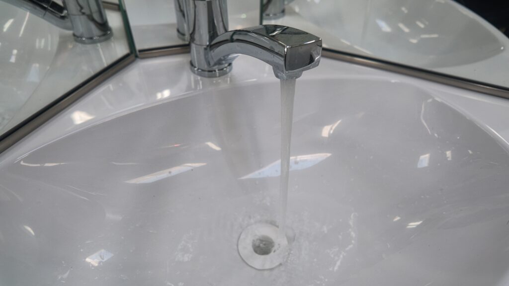 トイレの洗面台蛇口から水が出ている画像